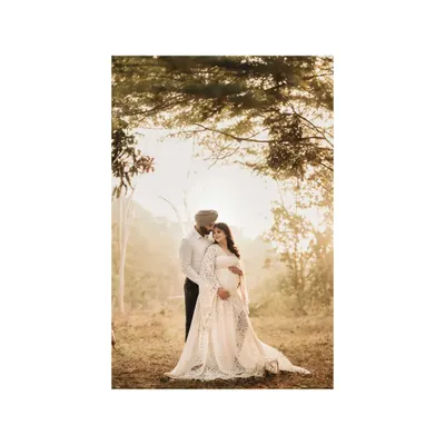 In the magical light of a forest at sunset, an expecting couple shares a quiet, intimate moment. This outdoor maternity photoshoot captures the deep affection and anticipation of their journey into parenthood.