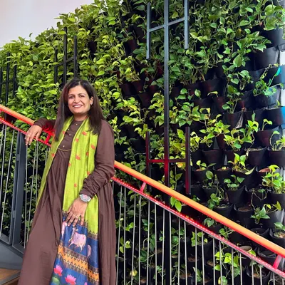 I'm standing proudly next to our "Narcissus Project," a living vertical garden installed along a staircase. This wall of lush pothos plants brings so much life and fresh air to the space, turning a simple stairwell into a beautiful experience.