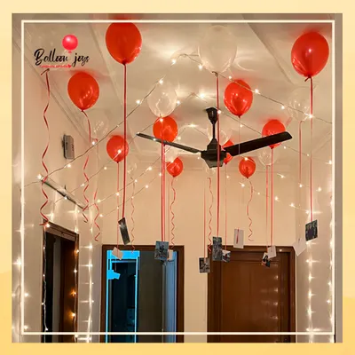I love turning memories into part of the decor. This simple yet powerful setup uses helium balloons to float your favorite photographs from the ceiling, surrounded by the warm glow of fairy lights for a truly personal and romantic atmosphere.