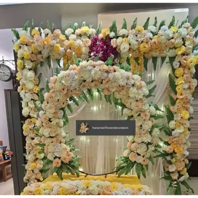 A lush and elegant floral frame I created for a Ganesh Chaturthi celebration. This design uses a mix of pastel yellow and peach roses with green foliage to create a soft and sophisticated backdrop for the idol.