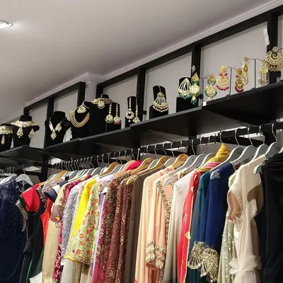 Our store is a treasure trove of designer wear, with racks organized to help you browse easily. You can also see our collection of statement jewelry displayed above, perfect for completing your look.