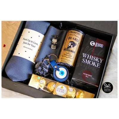 Our 'Styled with Love' hamper is the perfect gift for him. It includes a stylish tie and cufflinks, Beardo beard oil, Whisky Smoke perfume, and an evil eye keychain for good vibes.