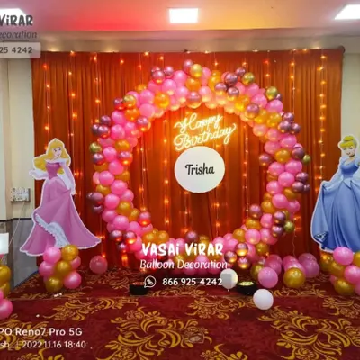A royal celebration for little Trisha's first birthday. This princess theme features a beautiful balloon ring in pink and gold, life-sized cutouts of Cinderella and Aurora, and a glowing marquee number '1'.