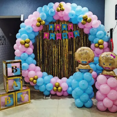 Celebrating with a splash of color. This baby shower setup is perfect for a gender reveal, with a full balloon ring in pink and blue, a sparkling gold backdrop, and cute baby-themed props to make the moment pop. 🎈