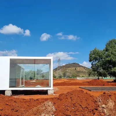 The very beginning of a new project. This minimalist glass structure is placed on the raw red earth, a blank canvas upon which a holistic masterplan for ecological and landscape design will unfold.