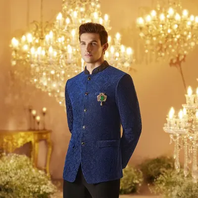 A royal blue textured bandhgala jacket styled for a Louis Philippe campaign. The look is elevated with a jeweled brooch, creating a regal and sophisticated ensemble perfect for a wedding or formal event.