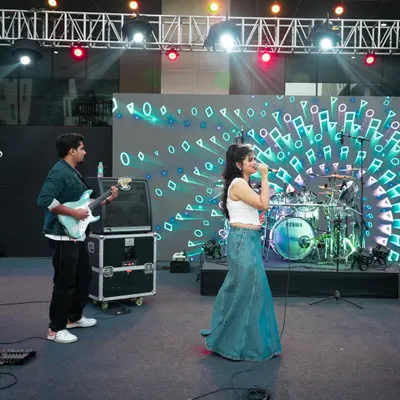 Performing on a large, professionally lit stage with my guitarist. This wide shot shows our duo setup for a concert, complete with a large LED screen backdrop.