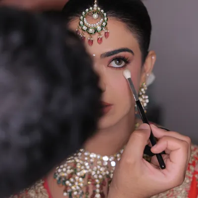 The art is in the details. A behind-the-scenes shot capturing the precise application of eyeshadow. Every brushstroke is intentional, aimed at creating a look that is perfect for the bride.
