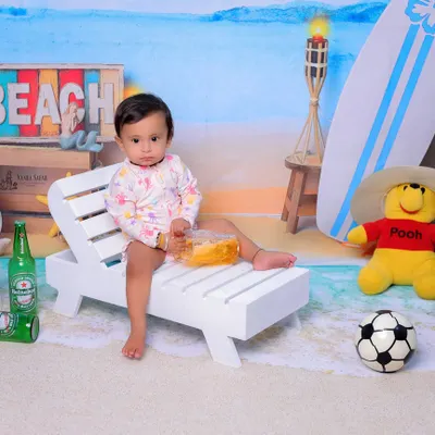 Relaxing on the studio beach. This little one is enjoying the props, creating a relaxed and happy vibe for her 11-month-old photoshoot.