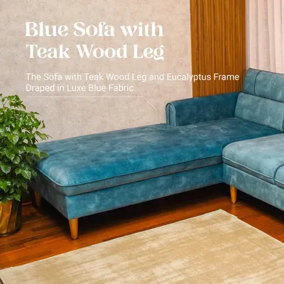 This custom L-shaped sectional in a striking blue Luxe fabric features a chaise lounge for ultimate relaxation. The solid Teak wood legs provide a warm, natural contrast to the contemporary design.