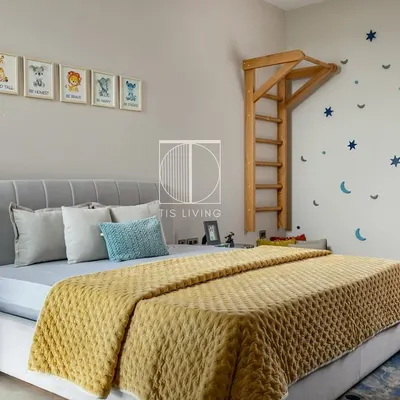 This kids' room is designed for imagination and play. We built the custom bed with a soft, channel-tufted headboard, the playful wall ladder, and the star and moon wall decals to create a magical space.