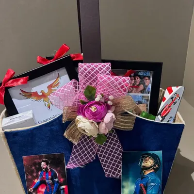 A graduation hamper for a sports fan. This gift celebrates a huge milestone with personalized touches like Messi and Dhoni photos, custom frames, and a mini canvas painting.