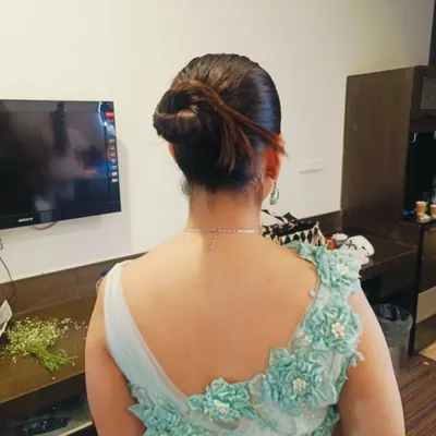 A modern and chic textured bun with a few loose strands to frame the face. This updo is perfect for a cocktail party or reception, pairing beautifully with an elegant gown.