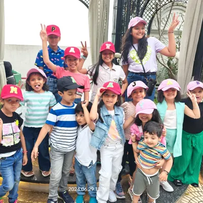 A large group of happy kids posing together in their custom initial caps after a fun party activity. This is the kind of group fun and memorable favor our live station creates.