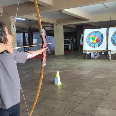 A young archer takes aim with great concentration. Learning to block out distractions is a key mental skill we practice.