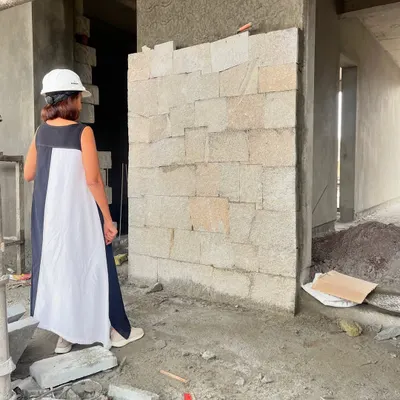 Our process is deeply hands-on. Here, we are on-site inspecting a mock-up wall of hand-cut stone, ensuring the texture, color, and jointing meet our exact specifications before full-scale construction begins. This attention to detail is what makes our work special.