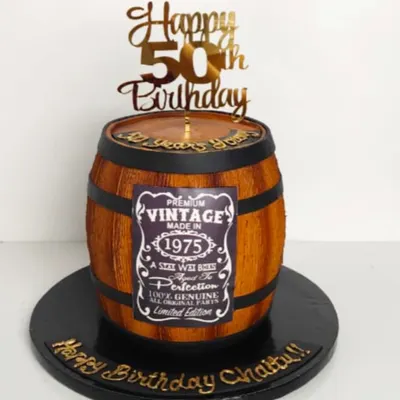 Aged to perfection. This cake is sculpted to look like a vintage whiskey barrel, complete with wood grain texture and a personalized "Vintage" label, celebrating a 50th birthday in style.