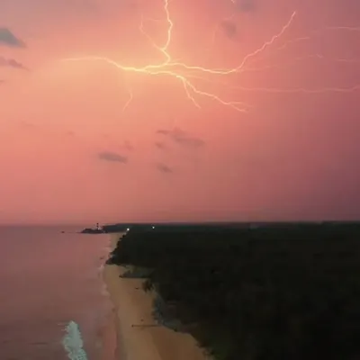 A perfectly timed aerial shot of lightning striking over the Kapu coastline, creating a dramatic pink and purple sky. This demonstrates my ability to capture rare and stunning natural phenomena with my drone.