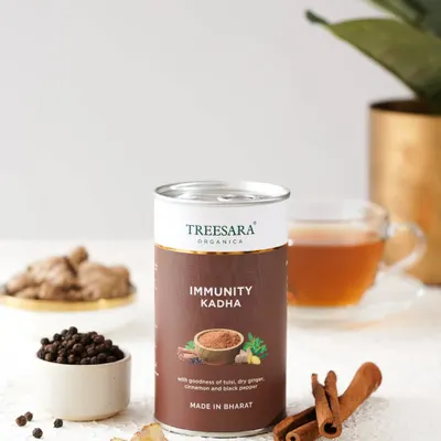 A beautifully styled shot of Immunity Kadha powder, surrounded by its core ingredients: cinnamon, black pepper, and ginger. This composition visually communicates the product's natural and healthful properties.