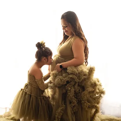 A truly precious moment of an older sister kissing her mother's baby bump. These are the memories that families will cherish forever.