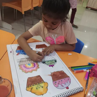Our cupcake project is a super fun way to learn about texture. Here, a student is carefully coloring her designs before adding collage materials.