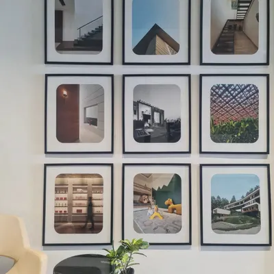 A glimpse of life in our studio, with a gallery wall displaying photographs of our diverse projects. This wall serves as a constant source of inspiration and a testament to the architectural stories we have created.