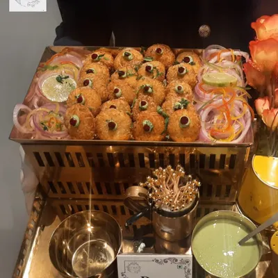 Our Dahi Ke Kebabs are a must-try. Crispy on the outside and soft on the inside, they are served on a beautiful golden tray with fresh mint chutney, making for a perfect vegetarian starter.