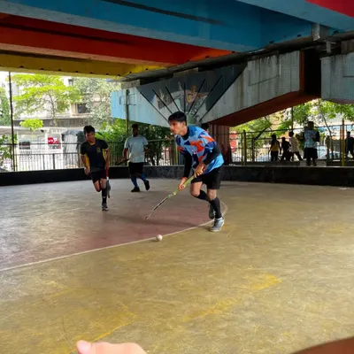 A junior player dribbles the ball down the court during a fast-paced rink hockey session. Our practices focus on quick thinking and sharp stick skills.