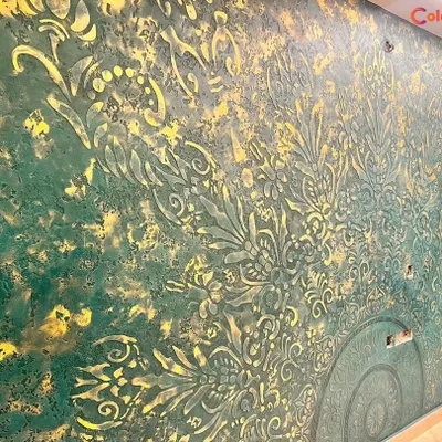 This is a close-up of a highly detailed embossed texture in a rich green and gold palette. This custom finish creates a dramatic, three-dimensional effect that is perfect for a luxurious and opulent feature wall.