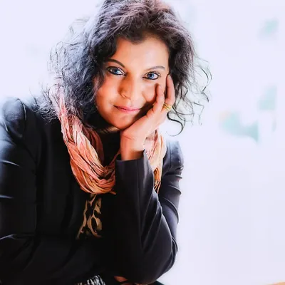 A bright, high-key color portrait where the subject connects directly with the camera. Her expressive eyes and gentle pose invite you into her world, showcasing the open and healing nature of the photo session.
