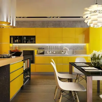 This open-plan kitchen and dining area features vibrant, high-gloss yellow cabinetry for a bold and energetic look. The kitchen island provides extra prep space and includes built-in shelving, while seamlessly connecting to the adjacent dining table. This design is perfect for those who love to entertain while they cook.