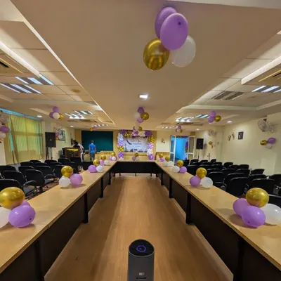 An overview of a conference room setup where my decorations add a touch of formality. The balloon arrangements are minimal to keep the focus on the event's proceedings.