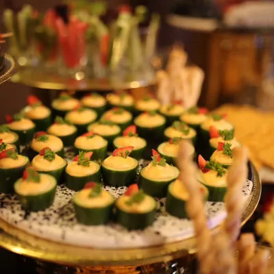 A close-up of my cucumber canapés, topped with a creamy hummus and garnished with fresh herbs and chili. These light and refreshing bites are a popular choice for cocktail hours.
