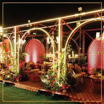 An enchanting evening setup featuring glowing arches and lush floral arrangements. We design every detail to create a magical atmosphere for your grand celebration.