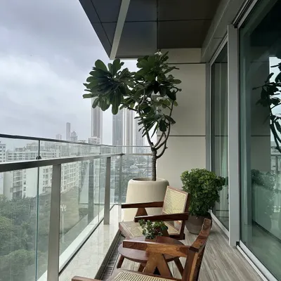 This balcony is an urban retreat, featuring my custom-designed mid-century modern chairs in wood and cane. The design provides a comfortable and stylish outdoor seating area that seamlessly merges with the city skyline.
