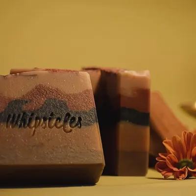 Our 5-layered Sandalwood soap, the grand finale of our Diwali collection. It's crafted to elevate your 'pahili anghol' with layers of activated charcoal, turmeric, and various natural clays.
