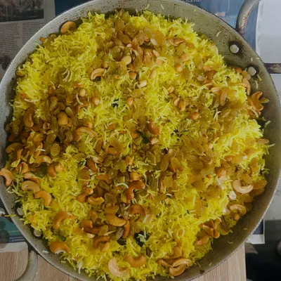Our flavorful Lemon Rice, garnished with fried cashews and raisins. It's a tangy and delicious part of our South Indian combo.