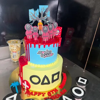 Red light, green light, time for cake! This two-tier Squid Game themed cake was a huge hit for a 6th birthday party. It features iconic symbols from the show and even comes with matching cupcakes, showing how we can bring any pop culture theme to life.
