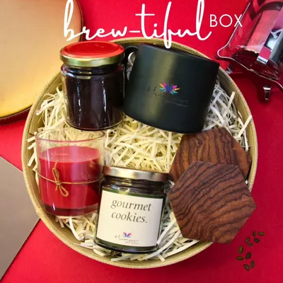 Our "Brew-tiful Box" is the perfect gift for any coffee aficionado. This curated hamper includes gourmet coffee, a custom-branded mug, artisanal cookies, elegant wooden coasters, and a scented candle to create a complete sensory experience.
