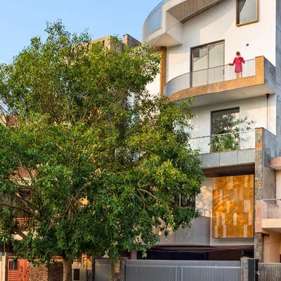 The exterior of the People Tree House, named 'Ashvattha', is designed in deference to the magnificent sacred fig tree that anchors the site. The architecture embraces the tree, making it the focal point and creating a sustainable residence where nature is not just outside, but a fundamental part of the home itself.