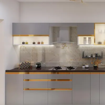 This modern kitchen design features warm grey cabinets with sleek gold-toned handles. The under-cabinet lighting beautifully illuminates the marble backsplash, creating a space that is both functional and luxurious.