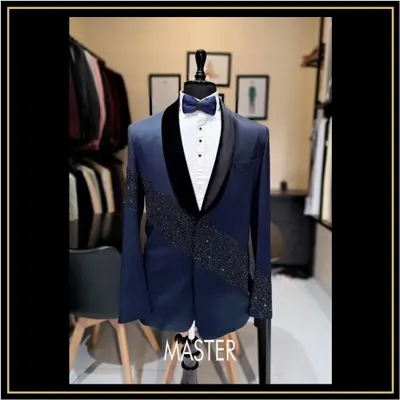 A closer look at this navy blue tuxedo, featuring a velvet shawl lapel and a diagonal spray of crystal work. This is a designer tuxedo for a groom who wants a touch of modern bling.