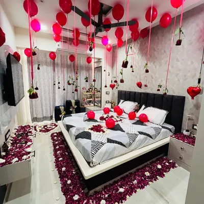 A full view of my signature romantic room decoration service. The design creates a complete sensory experience, from the pathway of deep red petals on the floor to the canopy of balloons and hanging roses above. This is the kind of memorable first night decoration that couples love.