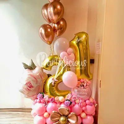 Turning 21 is a magical milestone. We celebrated it with this stunning rose-gold and blush pink balloon bouquet, featuring a large number display, a faux rose, and beautiful floral accents.