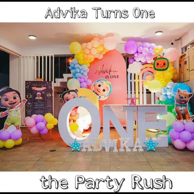 This Cocomelon party for Advika's first birthday is a perfect example of a complete and immersive theme. It features character cutouts, a personalized backdrop, a large 'ONE' prop for photos, and a beautiful pastel rainbow balloon arch.