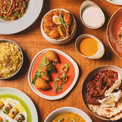 A full-spread flat lay showcasing a diverse menu. This type of shot is perfect for banners and promotional materials, giving a comprehensive look at a restaurant's offerings, including biryani, curries, and appetizers.