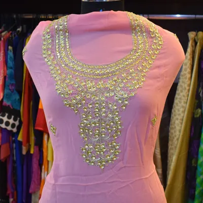 This pink georgette kurti features an elaborate neckline handcrafted with traditional gota patti work. It's a beautiful example of how a single, well-executed detail can elevate a simple silhouette into a designer piece.