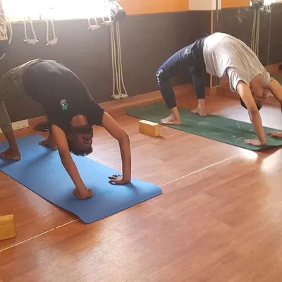 Two students practicing Chakrasana (Wheel Pose) on their mats. This advanced backbend is excellent for strengthening the spine, arms, and legs, and I ensure proper form for safety.