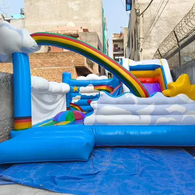 A unique rainbow and clouds-themed bouncy. This model features a slide that goes over a rainbow arch into a cloudy play area.