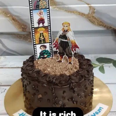 A chocolate chip cake for a "Demon Slayer" fan. This design features an edible film strip of characters and a cutout of the fan-favorite, Rengoku.